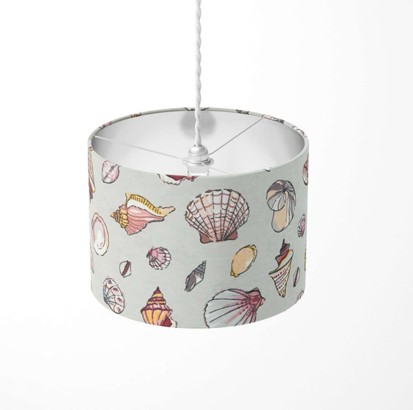 Grey seaside ceiling lampshade with pink sea shell pattern on a white background.