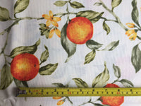 Cotton curtain upholstery fabric printed with orange fruit tree and green leaves on a white background.
