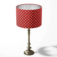 Bright red table lampshade patterned with white spots on a white background.