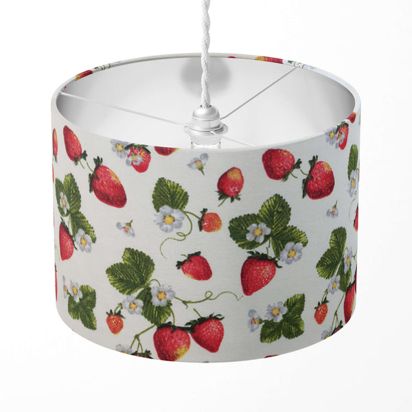 Lampshade with red strawberries and green leaves pattern on a white background.