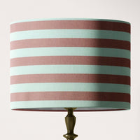 Striped lampshade with dusky pink and white horizontal stripes on a light pink background.