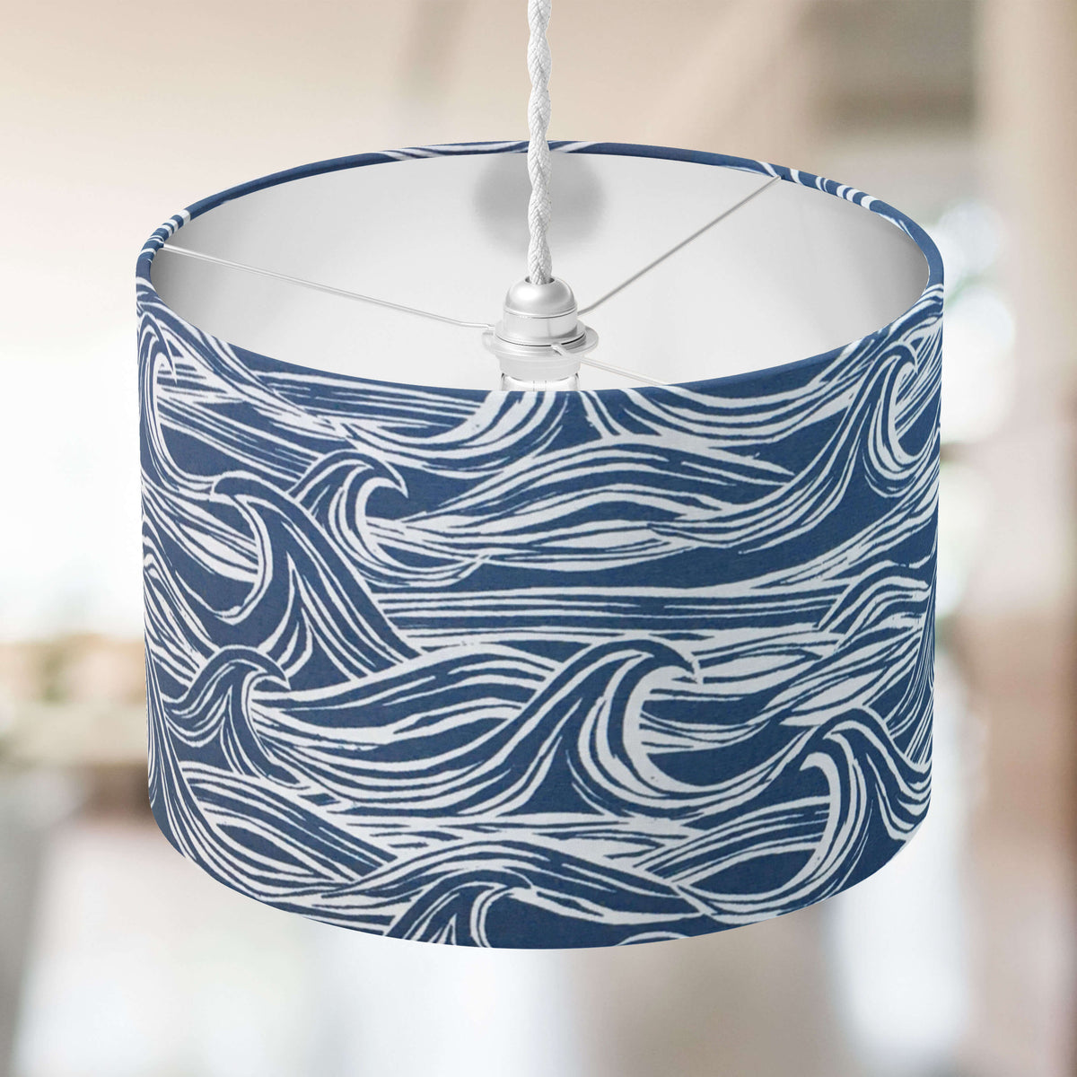 Nautical lampshade with denim blue and white wave pattern on a blurred background.
