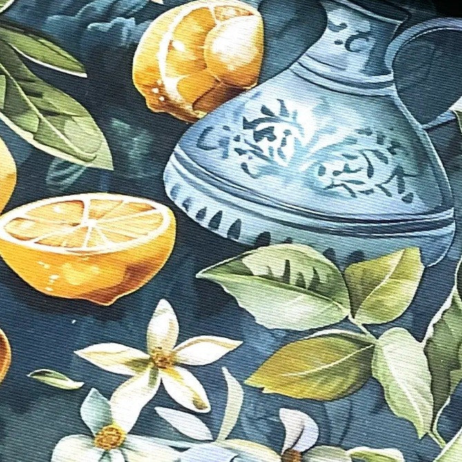 Boho tapestry upholstery fabric printed with copper vessel, yellow lemon, green leaves, white flowers on a teal blue background.