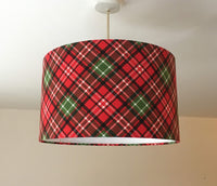 Red and green plaid lampshade on a white ceiling.