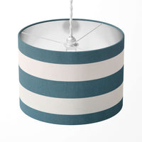 Horizontal striped lampshade with teal blue and white large stripes on a white background.