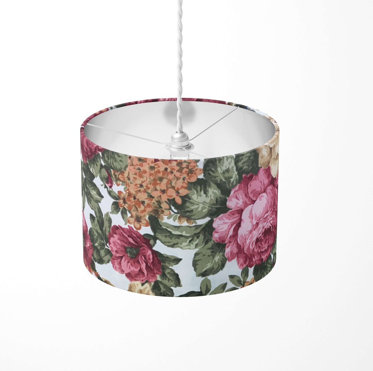 Red floral and green leaves patterned ceiling lampshade on a white background.