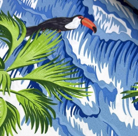 Toucan bird and palm leaves with blue wave patterned fabric.