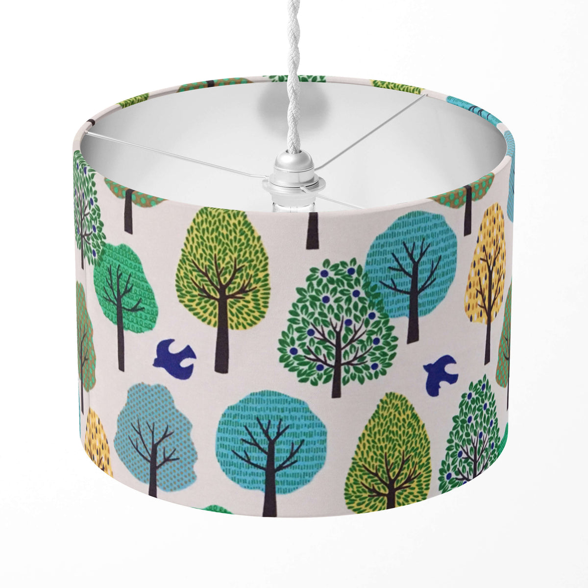 Green lampshade with tree and bird pattern on a white background.