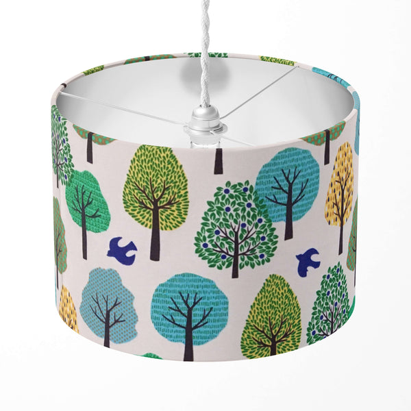 Green lampshade with tree and bird pattern on a white background.