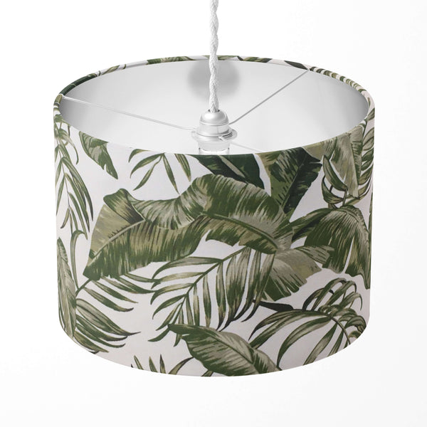 Lampshade with green tropical leaf pattern on a white background.