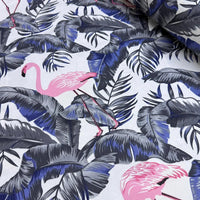 Upholstery curtain fabric patterned with pink flamingos and grey and blue leaves on a white background.