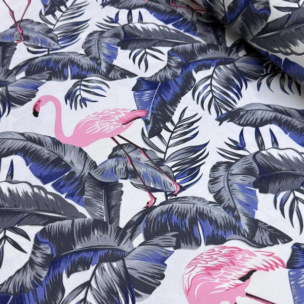 Upholstery curtain fabric patterned with pink flamingos and grey and blue leaves on a white background.