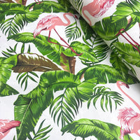 Tropical upholstery fabric with pink flamingo and green leaves pattern on a white background.