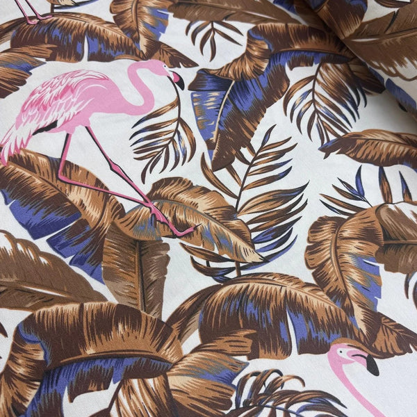 Tropical jungle fabric with pink flamingo and brown leaves on a white background.