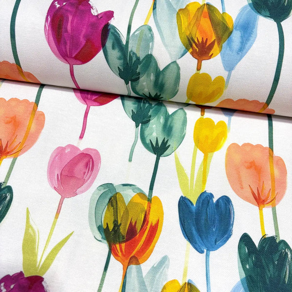 Upholstery & curtain fabric with colourful tulip garden pattern on a white background.