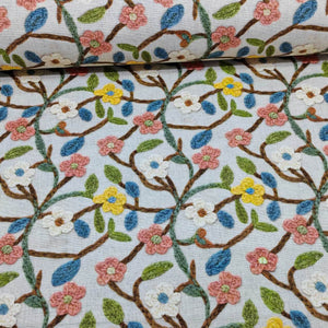 Vine flower upholstery curtain fabric featuring blush pink, blue, yellow, white flowers and green leaves.