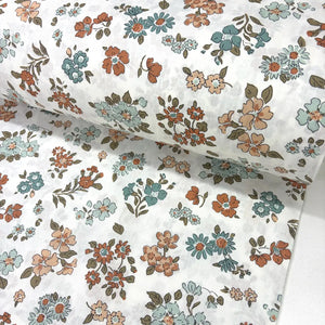 Vintage floral cotton fabric patterned with rust orange, teal blue, sage green flowers on a white background.