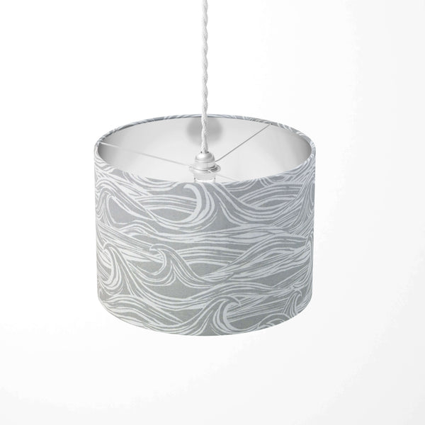 Cylindrical pendant light shade with sea wave pattern on a white background.