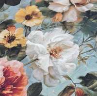 Close-up of a floral patterned fabric with white, yellow, and pink flowers on a blue background.