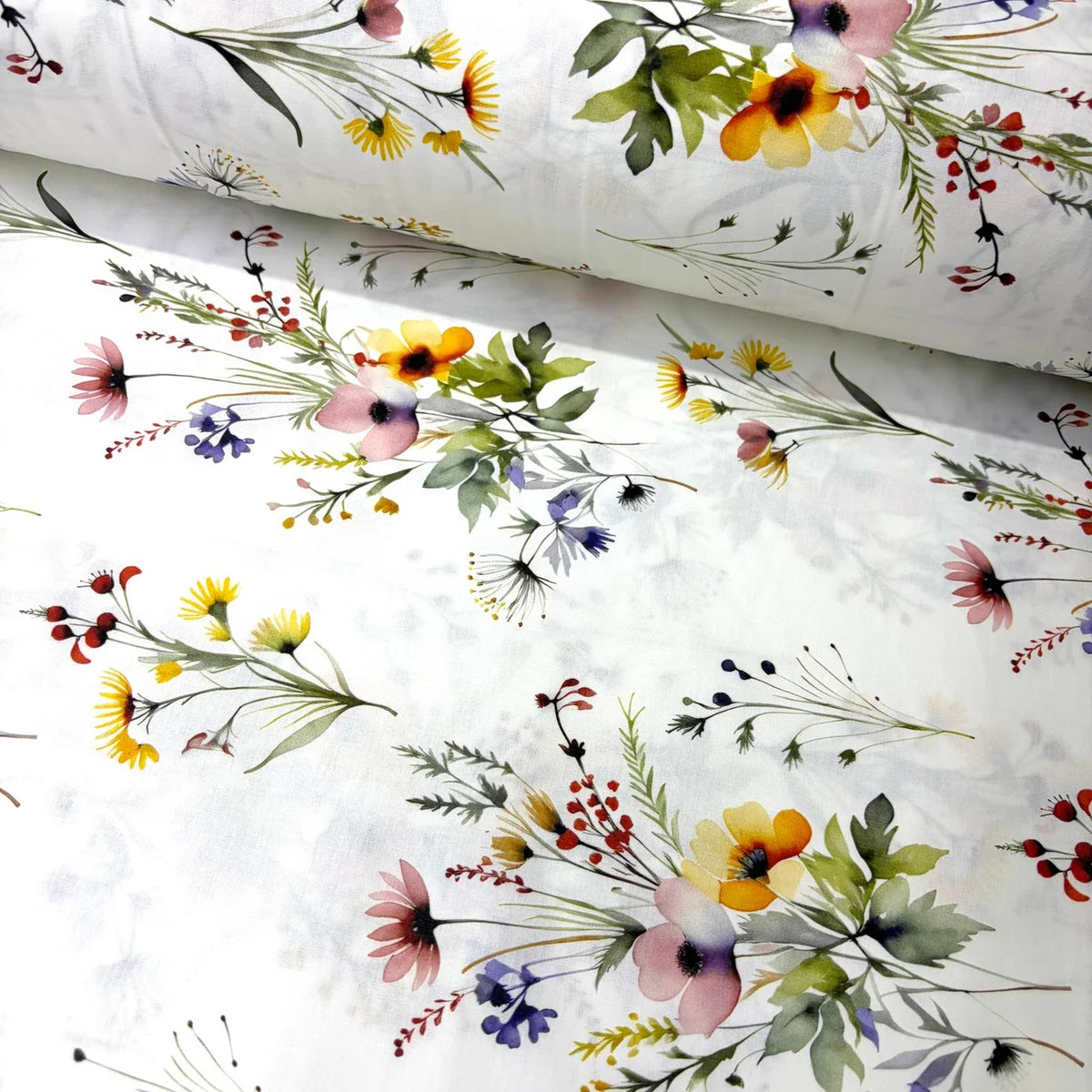 White cotton poplin fabric featuring colourful watercolour wildflower bouquets and botanical foliage, ideal for dressmaking, quilting, patchwork and craft projects.
