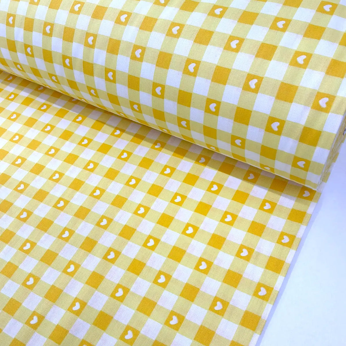 Yellow and white gingham check 100% cotton fabric with a heart print, ideal for quilting, patchwork, sewing, dressmaking, crafts, and home décor.