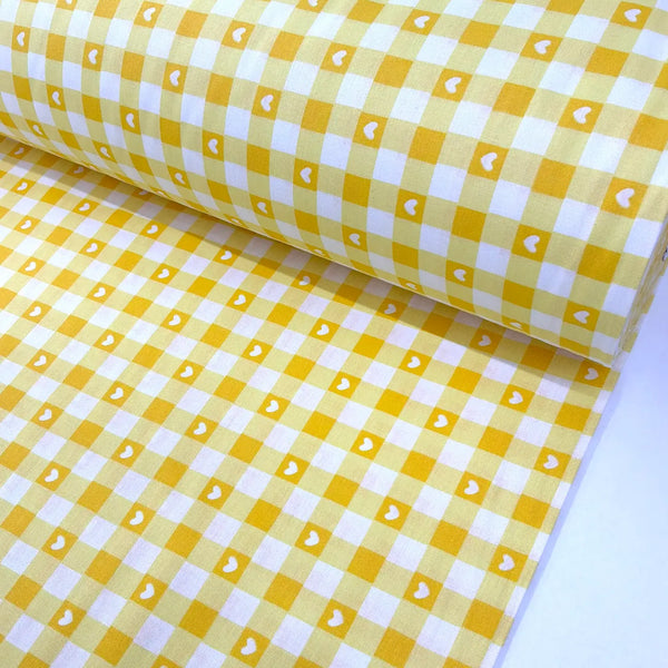 Yellow and white gingham check 100% cotton fabric with a heart print, ideal for quilting, patchwork, sewing, dressmaking, crafts, and home décor.