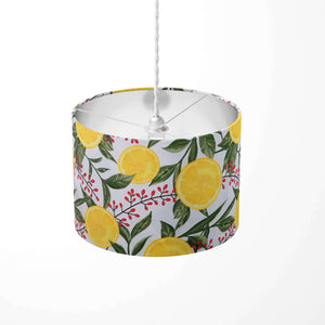 Ceiling lampshade patterned with yellow lemons, green leaves and red flowers on a white background. 