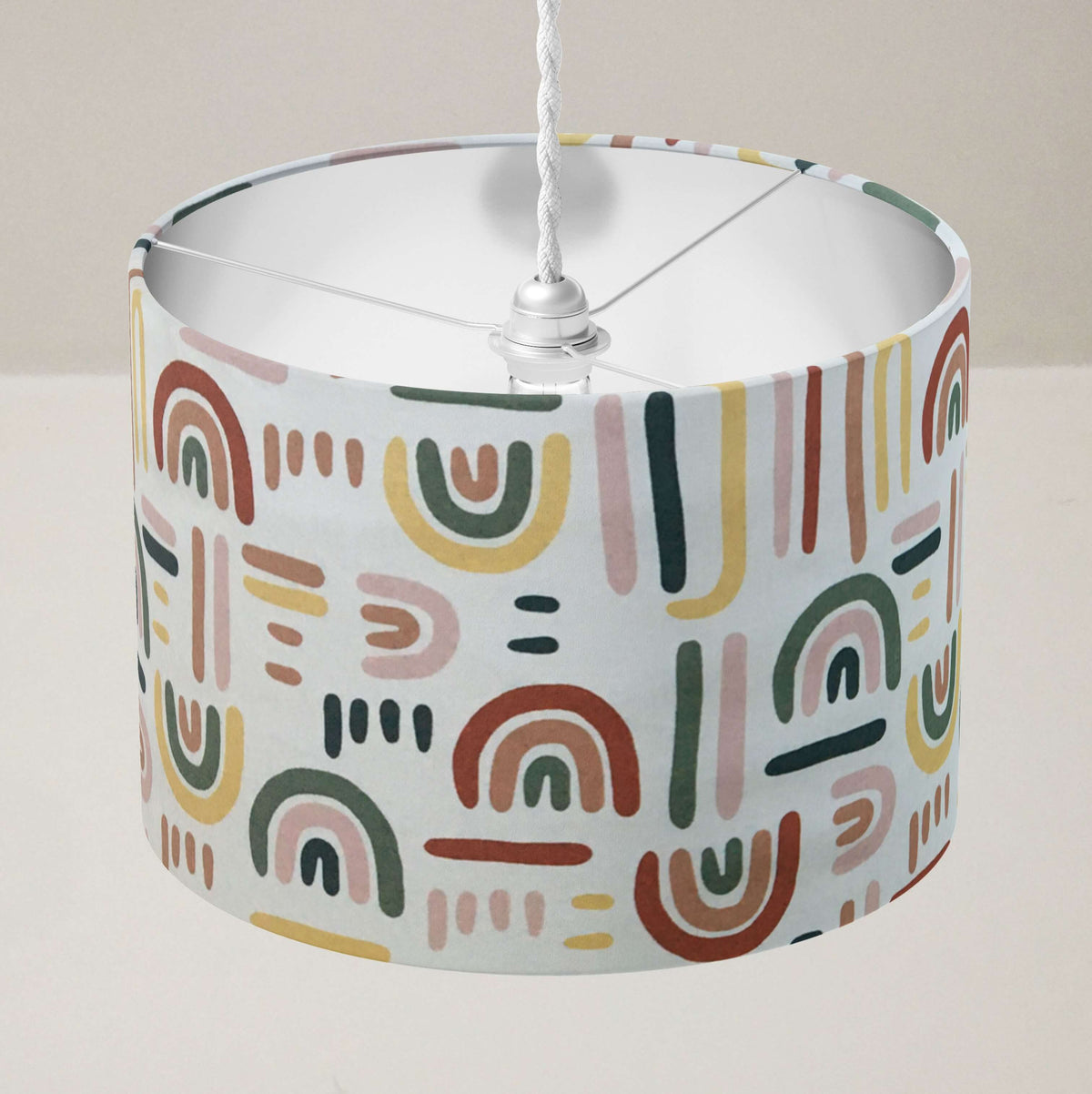 Colourful rainbow ceiling lampshade on a plain background.