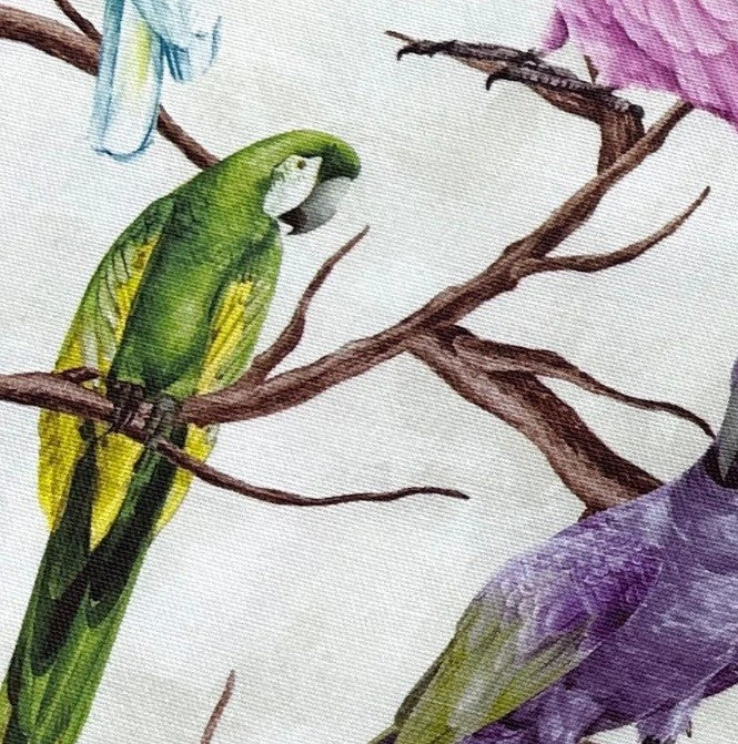 Green and lilac parrot and brown branch trees patterned upholstery fabric.