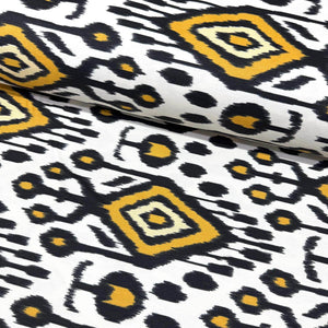 Tribal ikat upholstery fabric with black, yellow, and white geometric pattern.