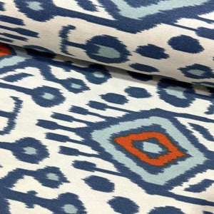 Close-up of ikat aztec traditional mallorca fabric with indigo blue and orange geometric pattern.