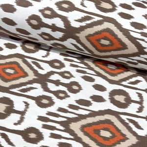 Ikat patterned upholstery curtain fabric with geometric design in brown, orange, and beige on a white background.