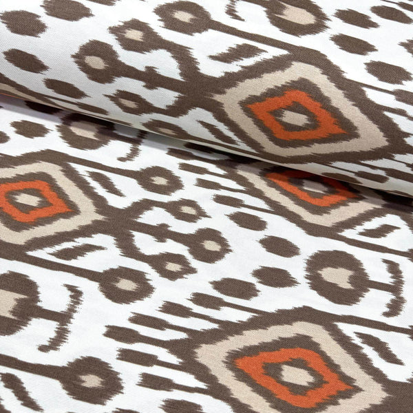 Ikat patterned upholstery curtain fabric with geometric design in brown, orange, and beige on a white background.