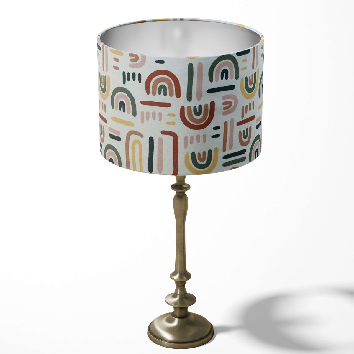 Children's room table lampshade in multi coloured rainbow pattern.
