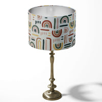 Children's room table lampshade in multi coloured rainbow pattern.