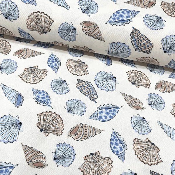 Upholstery curtain fabric with blue and brown sea shell pattern on a white background.
