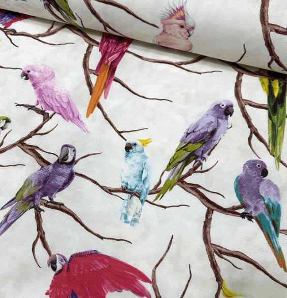 Colourful upholstery fabric patterned with exotic birds in pink, burgundy, purple, green and sky blue.  