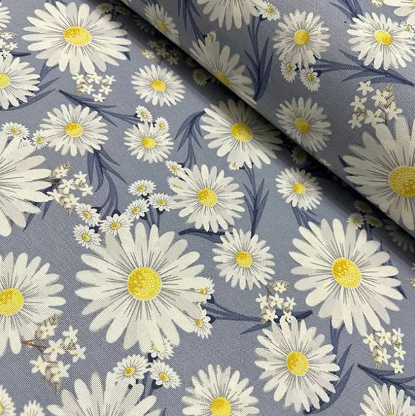 A curtain upholstery fabric displaying a floral pattern with white yellow daisies on an indigo blue background.