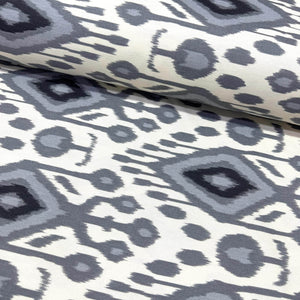 Ikat upholstery curtain fabric with black and gray geometric pattern on white background.
