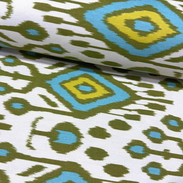 Ikat upholstery curtain fabric with green and blue geometric pattern on a white background.