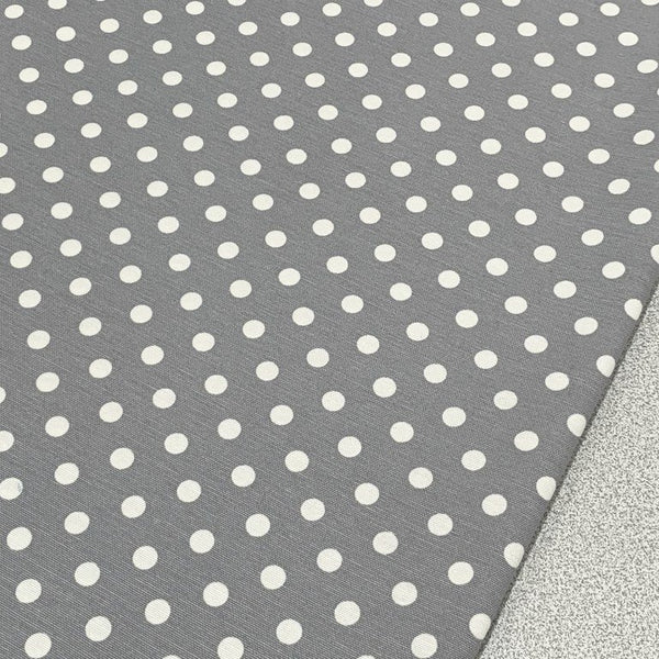 Grey dotted upholstery curtain fabric with white spots.