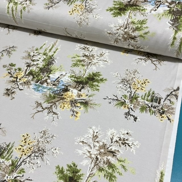 French toile upholstery fabric patterned with a village scene, gondola and green trees on a beige background.