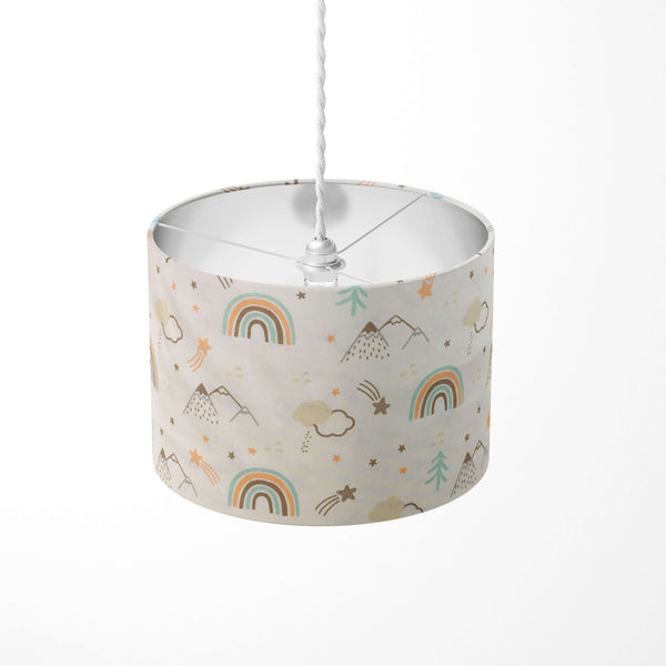 Rainbow, mountain, clouds, stars abd trees patterned ceiling lampshade on a white background.
