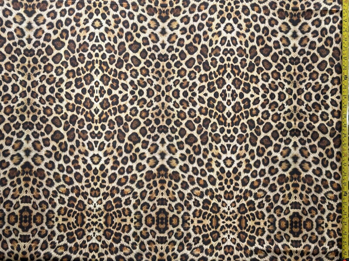 Cheetah print upholstery fabric with a measuring tape for scale.