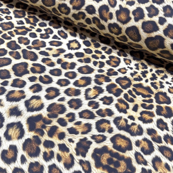 Leopard print upholstery fabric with brown and black spots on a beige background.