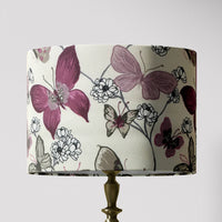 Lampshade with dusky pink and rose butterfly and white flowers design on a cream background.