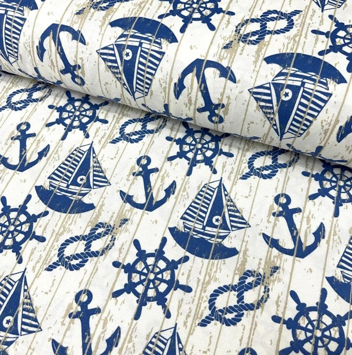 Blue white nautical fabric patterned with boats anchors rope knots and ship wheels