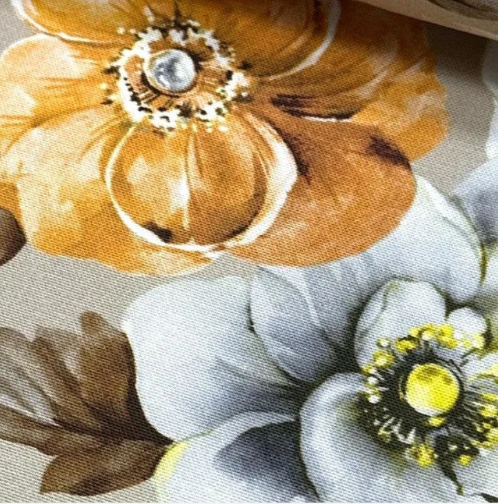 A close-up of mustard yellow and white anemone fabric.