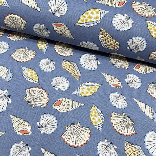Upholstery curtain fabric with sea shell pattern on a denim blue background.