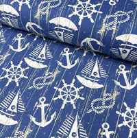 Cotton canvas fabric printed with white sailboats, anchors, knot ropes, ship wheels and denim blue sea.